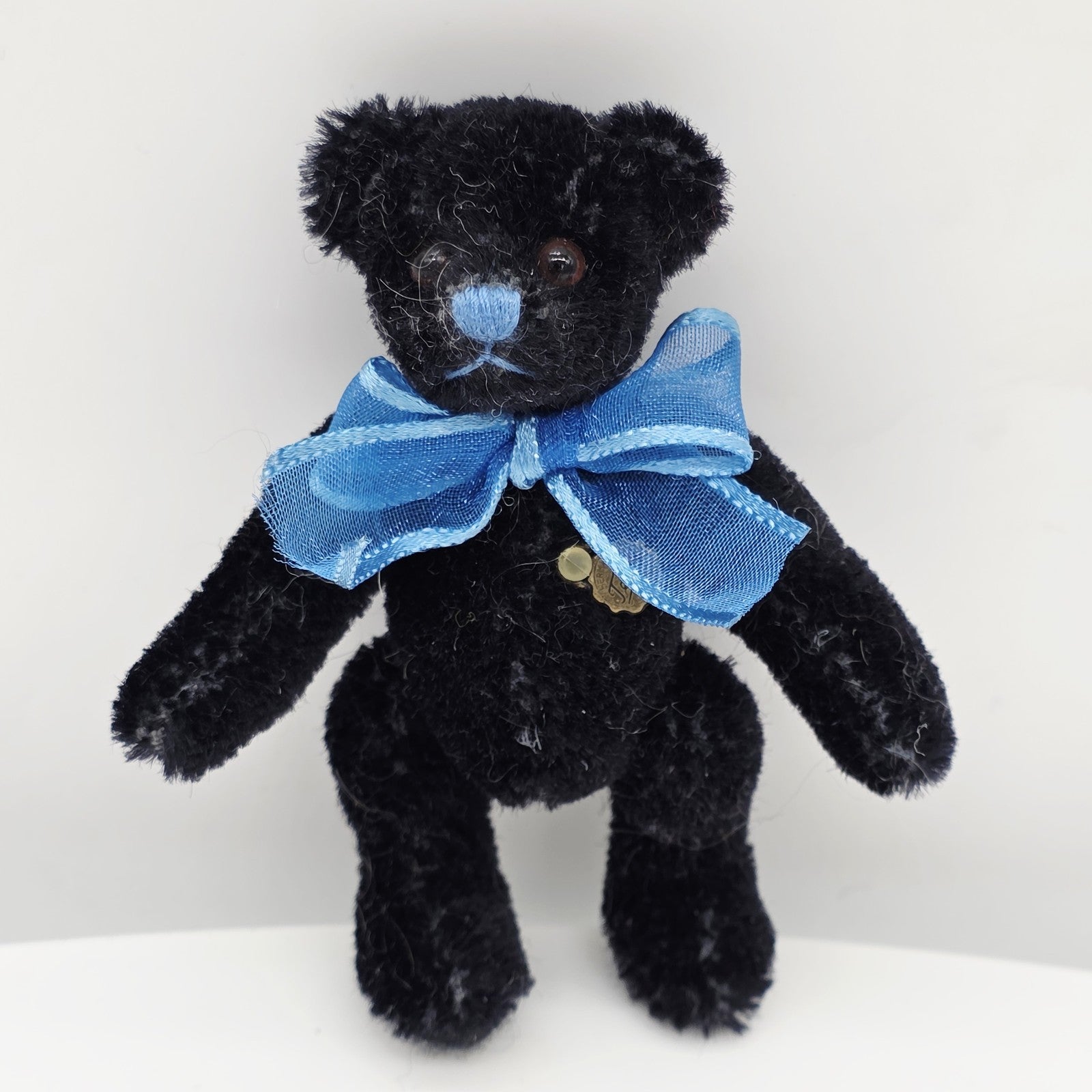 Hermann Teddy Miniatur 10 cm schwarz mit blauer Schleife –